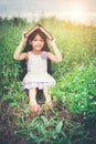 Little cute asian girl cover book on her head at nature. Royalty Free Stock Photo