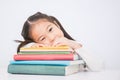 Little cute asian girl thinkig with stack of books ready to school.