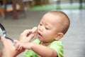 Little cute Asian infant girl interested mother doing make up. Mother playing with daughter brushes her baby cheek Royalty Free Stock Photo