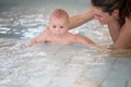 Little cute baby boy, swimming happily in a shallow pool water Royalty Free Stock Photo