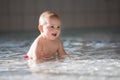 Little cute baby boy, swimming happily in a shallow pool water Royalty Free Stock Photo