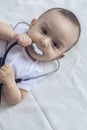 Little cute baby doctor. 6-month old baby boy playing with stethoscope. Kid having fun like a doctor Royalty Free Stock Photo