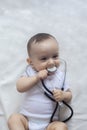 Little cute baby doctor. 6-month old baby boy playing with stethoscope. Kid having fun like a doctor Royalty Free Stock Photo