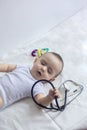 Little cute baby doctor. 6-month old baby boy playing with stethoscope. Kid having fun like a doctor Royalty Free Stock Photo
