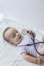 Little cute baby doctor. 6-month old baby boy playing with stethoscope. Kid having fun like a doctor Royalty Free Stock Photo