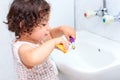 Little cute baby girl cleaning her teeth with toothbrush in the bathroom. Royalty Free Stock Photo