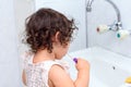 Little cute baby girl cleaning her teeth with toothbrush in the bathroom. Royalty Free Stock Photo