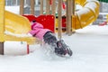 Little cute baby girl having fun on playground at winter. Children winter sport and leisure outdoor activities Royalty Free Stock Photo