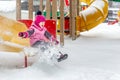 Little cute baby girl having fun on playground at winter. Children winter sport and leisure outdoor activities Royalty Free Stock Photo