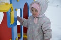 Little cute baby girl having fun on playground at winter. Children winter sport and leisure outdoor activities Royalty Free Stock Photo