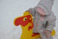 Little cute baby girl having fun on playground at winter. Children winter sport and leisure outdoor activities Royalty Free Stock Photo