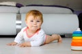 Little cute baby girl learning to crawl. Healthy child crawling in kids room. Smiling happy healthy toddler girl. Cute