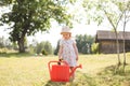 A little cute baby girl 3-4 years old in a dress watering the plants from a watering can in the garden. Kids having fun Royalty Free Stock Photo