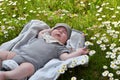 Little cute baby resting on the grass lawn with daisies
