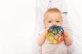 Baby boy toddler play and hold toy ball near mouth