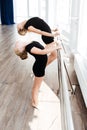 Little cute ballerina and her teacher stretching in dance studio