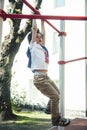 Little cute blond boy hanging on playground outside, alone training with fun, lifestyle children concept Royalty Free Stock Photo