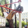 Little cute blond boy hanging on playground outside, alone training with fun, lifestyle children concept Royalty Free Stock Photo