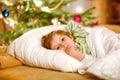 Little cute blond boy sleeping under Christmas tree and dreaming of Santa at home, indoors. Traditional Christian Royalty Free Stock Photo