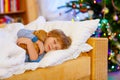 Little cute blond child sleeping under Christmas tree Royalty Free Stock Photo