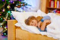 Little cute blond child sleeping under Christmas tree Royalty Free Stock Photo