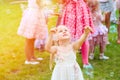 Little cute blond girl in a dress playing with soap bubbles duri Royalty Free Stock Photo