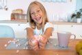 Little cute blond girl in the kitchen having her breakfast having fun with marshmallow and smiling. This is so tasty Royalty Free Stock Photo