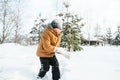 Little cute boy in black hat,orange jacket is lying,playing in snow. Kid walking in beautiful frozen forest,park among Royalty Free Stock Photo