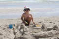 Little cute boy builds a sand castle. House of sand on the beach Royalty Free Stock Photo