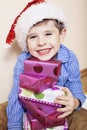 Little cute boy with Christmas gifts at home