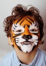 Little cute boy with faceart on birthday party close up, little cute tiger Royalty Free Stock Photo