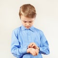 Little cute boy fastened the buttons on sleeve bright shirt