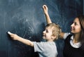 Little cute boy in glasses with young real teacher, classroom studying at blackboard school kido Royalty Free Stock Photo