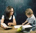 Little cute boy in glasses with young real teacher, classroom studying at blackboard school kido Royalty Free Stock Photo