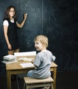 Little cute boy in glasses with young real teacher, classroom studying at blackboard school kido Royalty Free Stock Photo