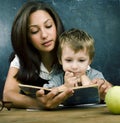 Little cute boy in glasses with young real teacher, classroom studying at blackboard school kido Royalty Free Stock Photo