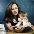 Little cute boy in glasses with young real teacher, classroom studying at blackboard school kido Royalty Free Stock Photo