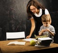 Little cute boy in glasses with young real teacher, classroom studying Royalty Free Stock Photo