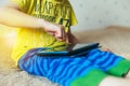 Little cute boy in a green T-shirt playing games on a tablet and watching cartoons. addiction concept Royalty Free Stock Photo