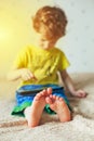 Little cute boy in a green T-shirt playing games on a tablet and watching cartoons. addiction concept Royalty Free Stock Photo