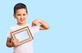 Little cute boy kid holding empty frame pointing finger to one self smiling happy and proud Royalty Free Stock Photo