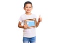 Little cute boy kid holding empty frame smiling happy and positive, thumb up doing excellent and approval sign Royalty Free Stock Photo