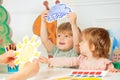 Boy, girl in the class play with weather rain and sun cards Royalty Free Stock Photo