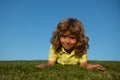 Little cute boy laying on grass. Kids exploring nature, summer.