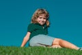 Little cute boy laying on grass. Kids exploring nature, summer.