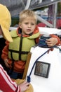 Little cute boy in life jacket on yacht.