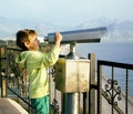 Little cute boy looking through telescope at sea viewpoint in At Royalty Free Stock Photo