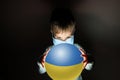 Little cute boy in medical mask holding a luminous planet Earth in her hands. Coronavirus in Ukraine. covid-19 concept