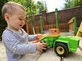 A little cute boy of one and a half years plays with toy car at the playground. Adorable toddler playing with cars and toys Royalty Free Stock Photo