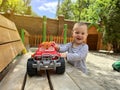 A little cute boy of one and a half years plays with toy car at the playground. Adorable toddler playing with cars and toys Royalty Free Stock Photo